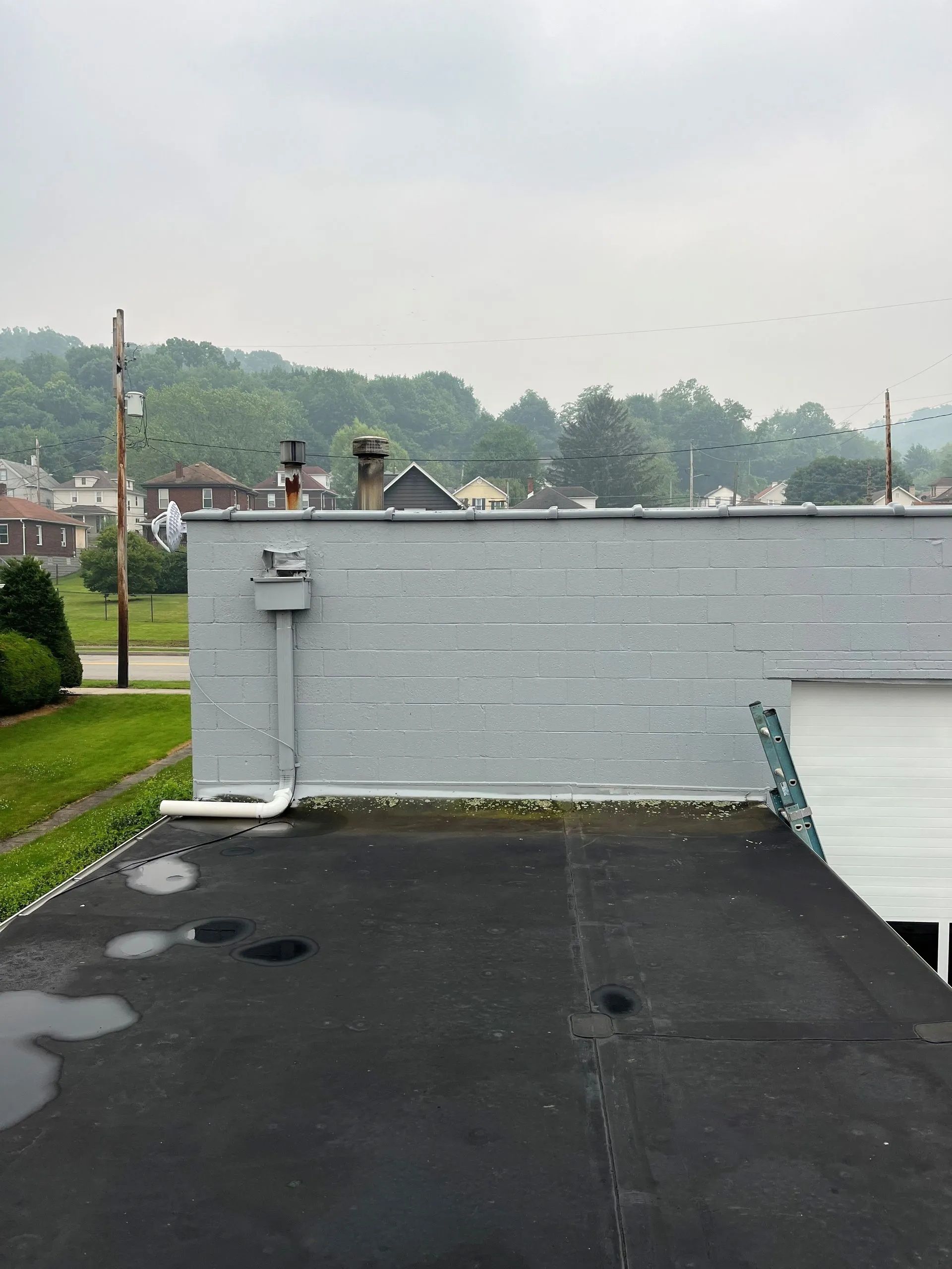 The roof of a building with a black roof and a gray wall.