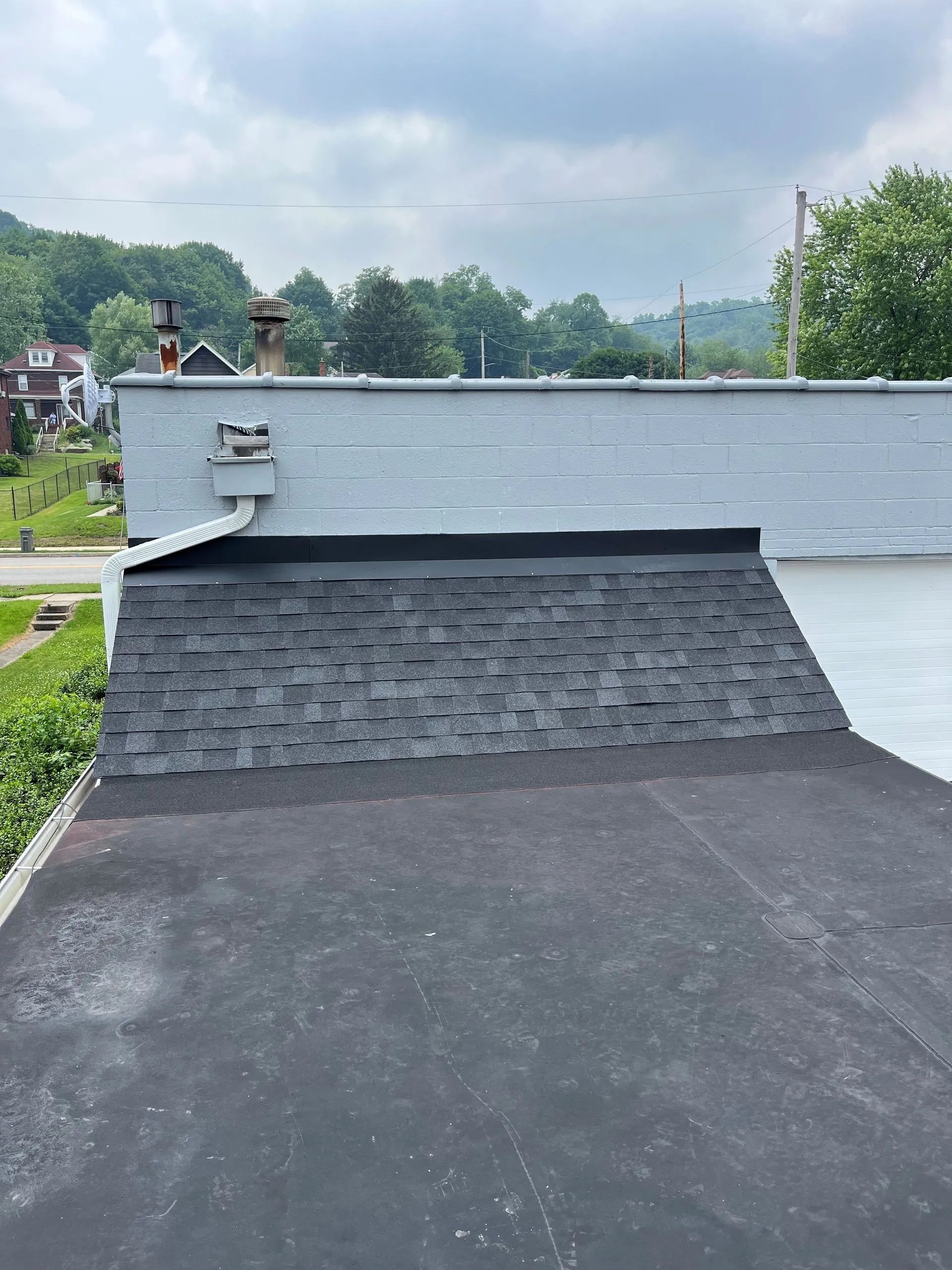 A house with a black roof and a white garage door.