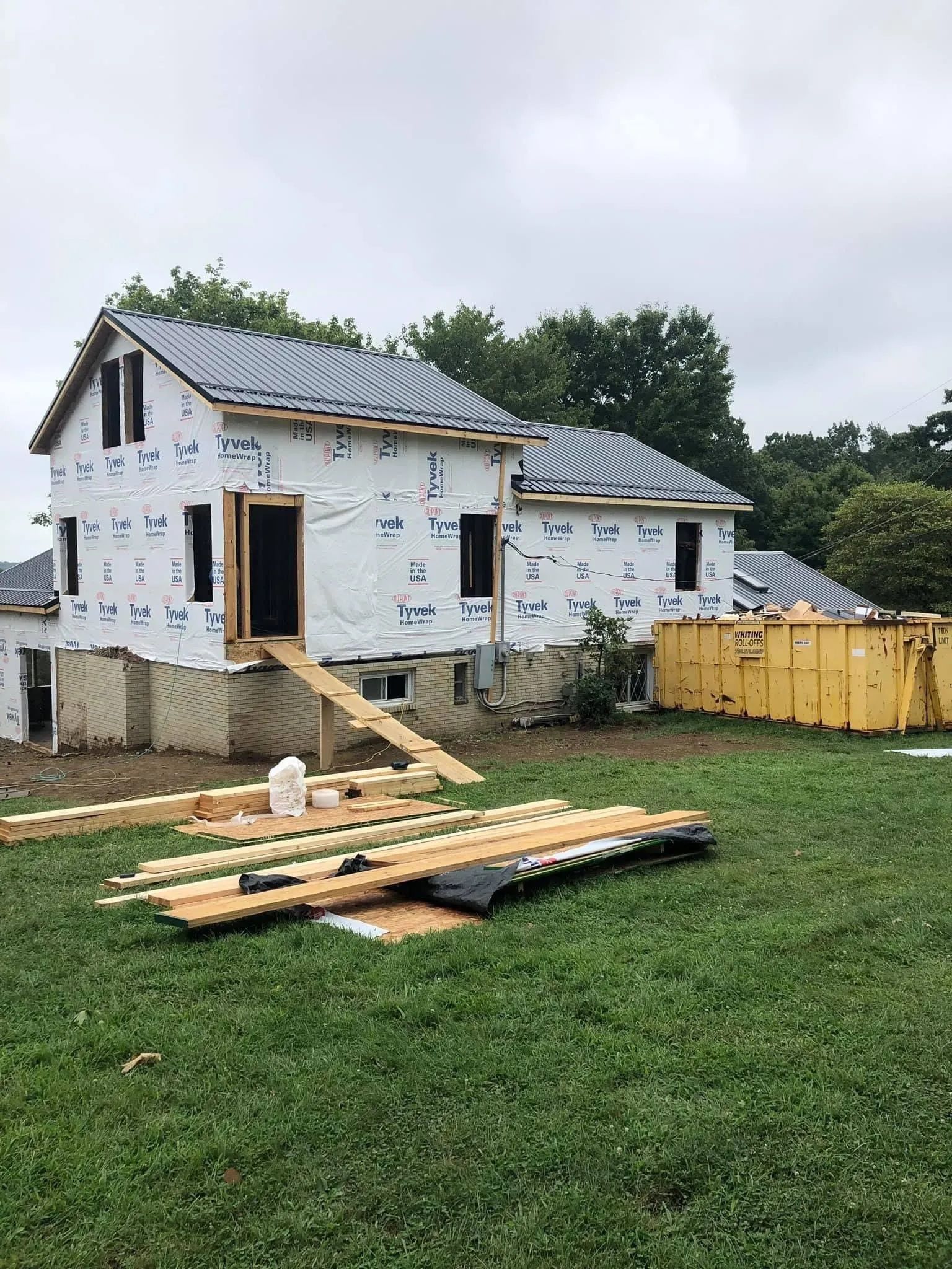 A house is being built in the middle of a grassy field.