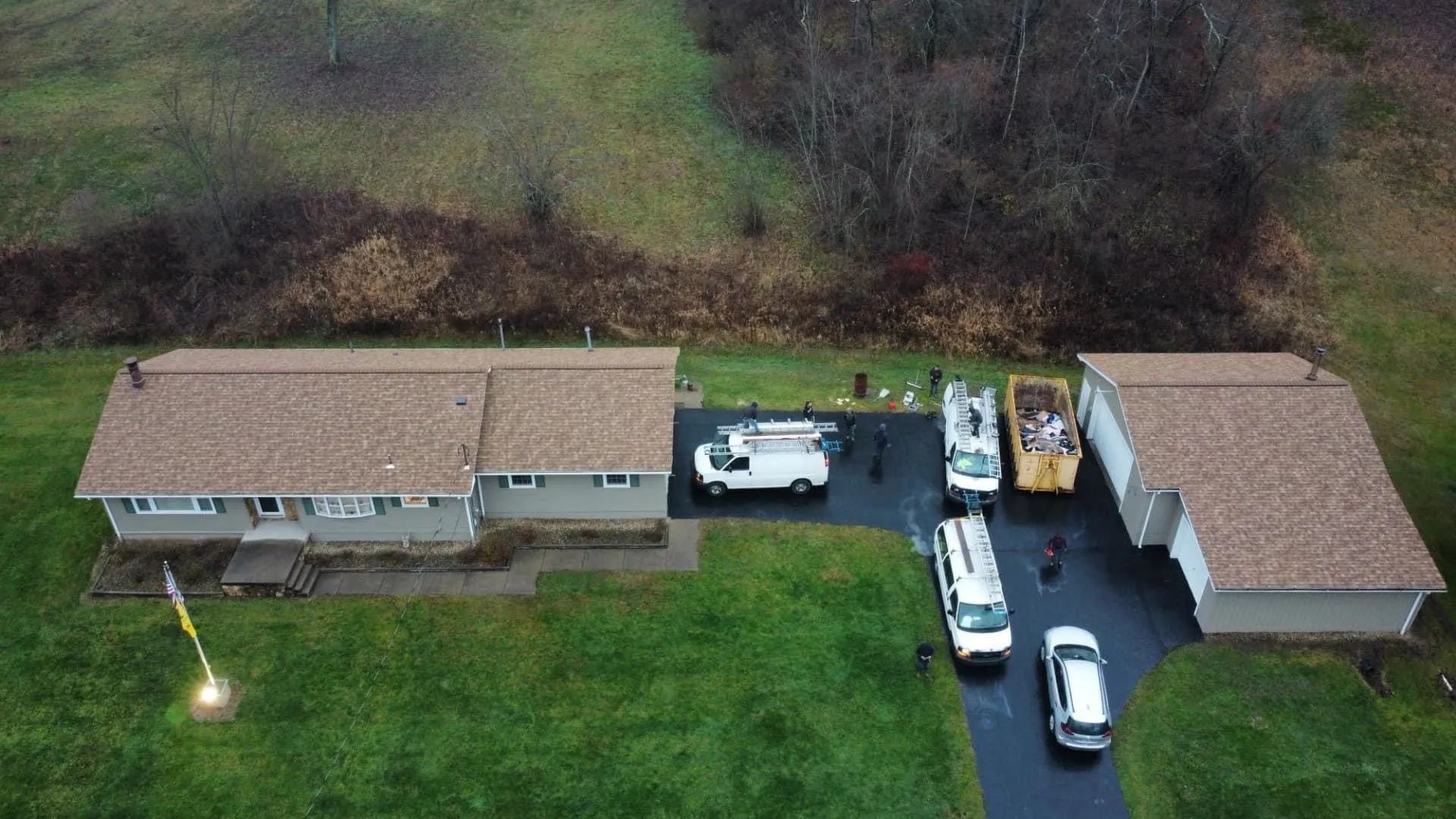 An aerial view of a house with a lot of cars parked in front of it.
