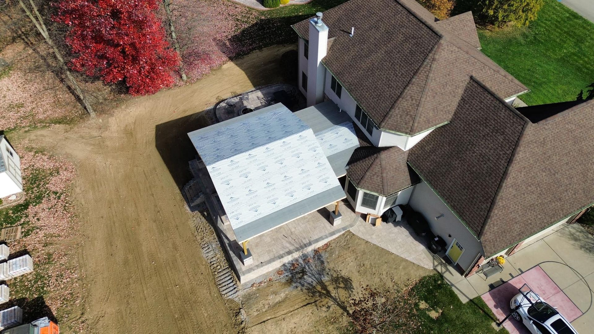 An aerial view of a large house with a roof that is covered in solar panels.