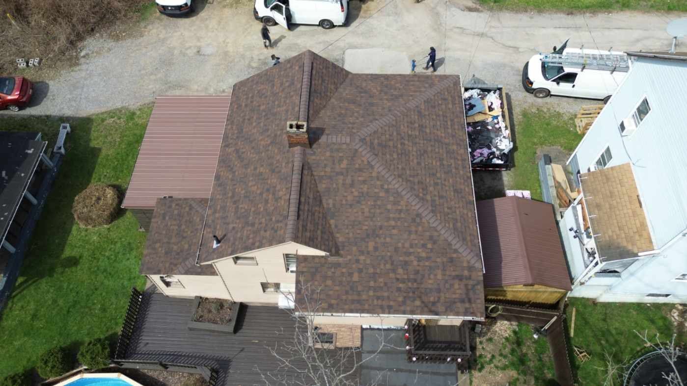 An aerial view of a house with a roof that is being repaired.