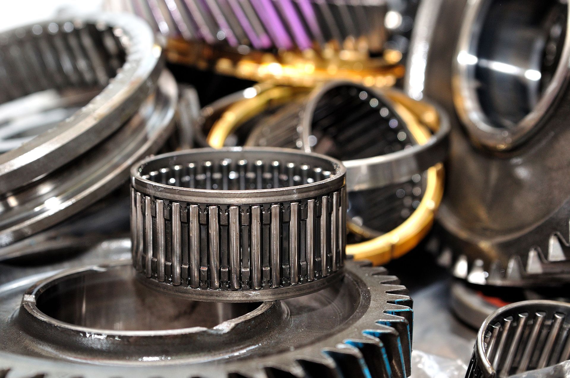 Close-up of disassembled automotive transmission parts, including gears and bearings.