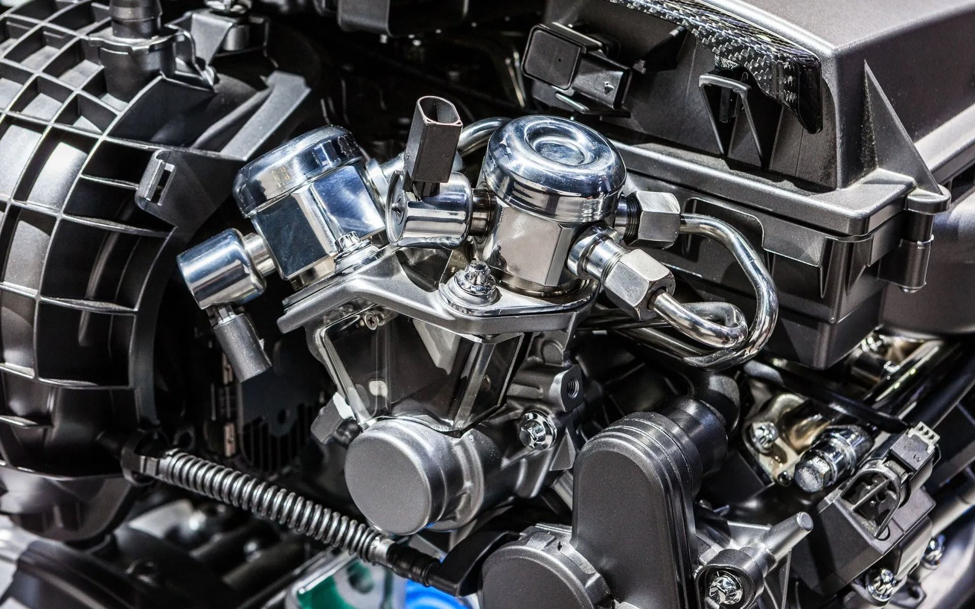 Close-up of a modern engine showing metallic components, including cylinders, fuel injectors, and piping.