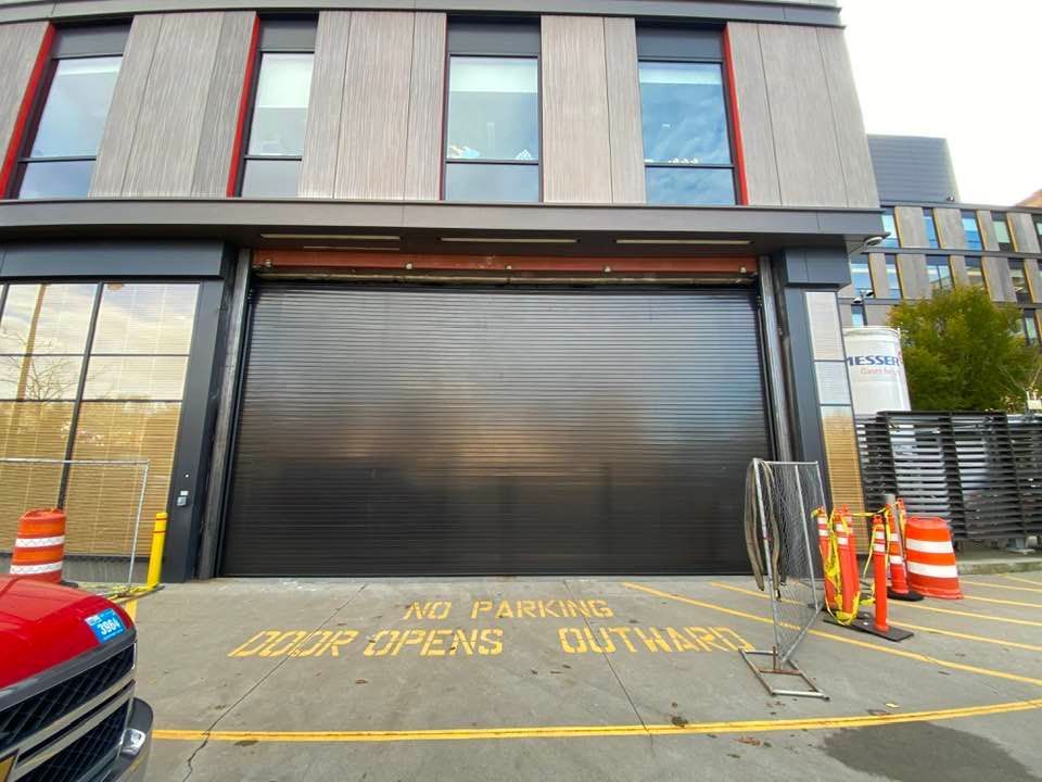 A car is parked in front of a building that says no parking