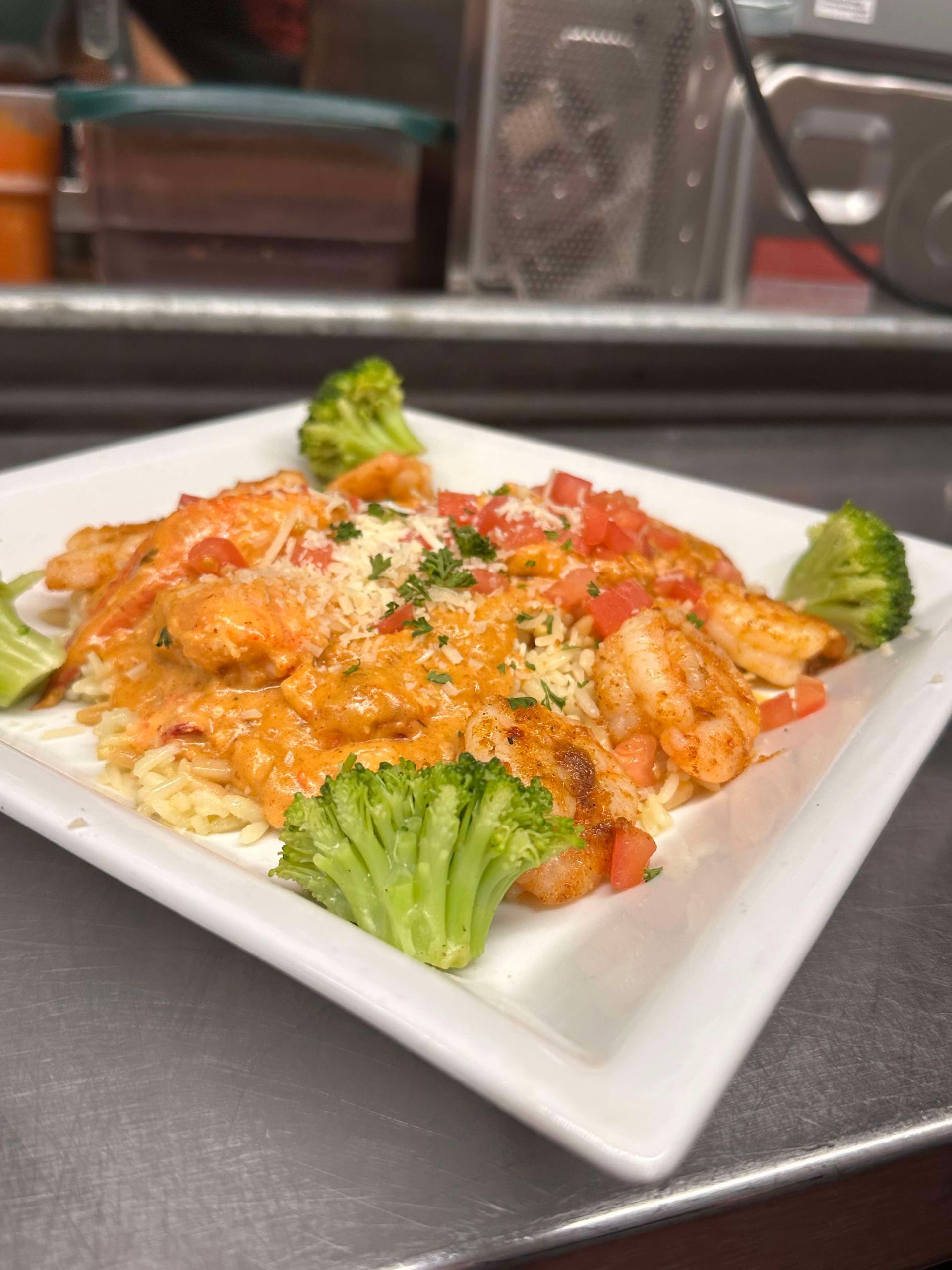 A white plate topped with pasta and chicken on a wooden table.