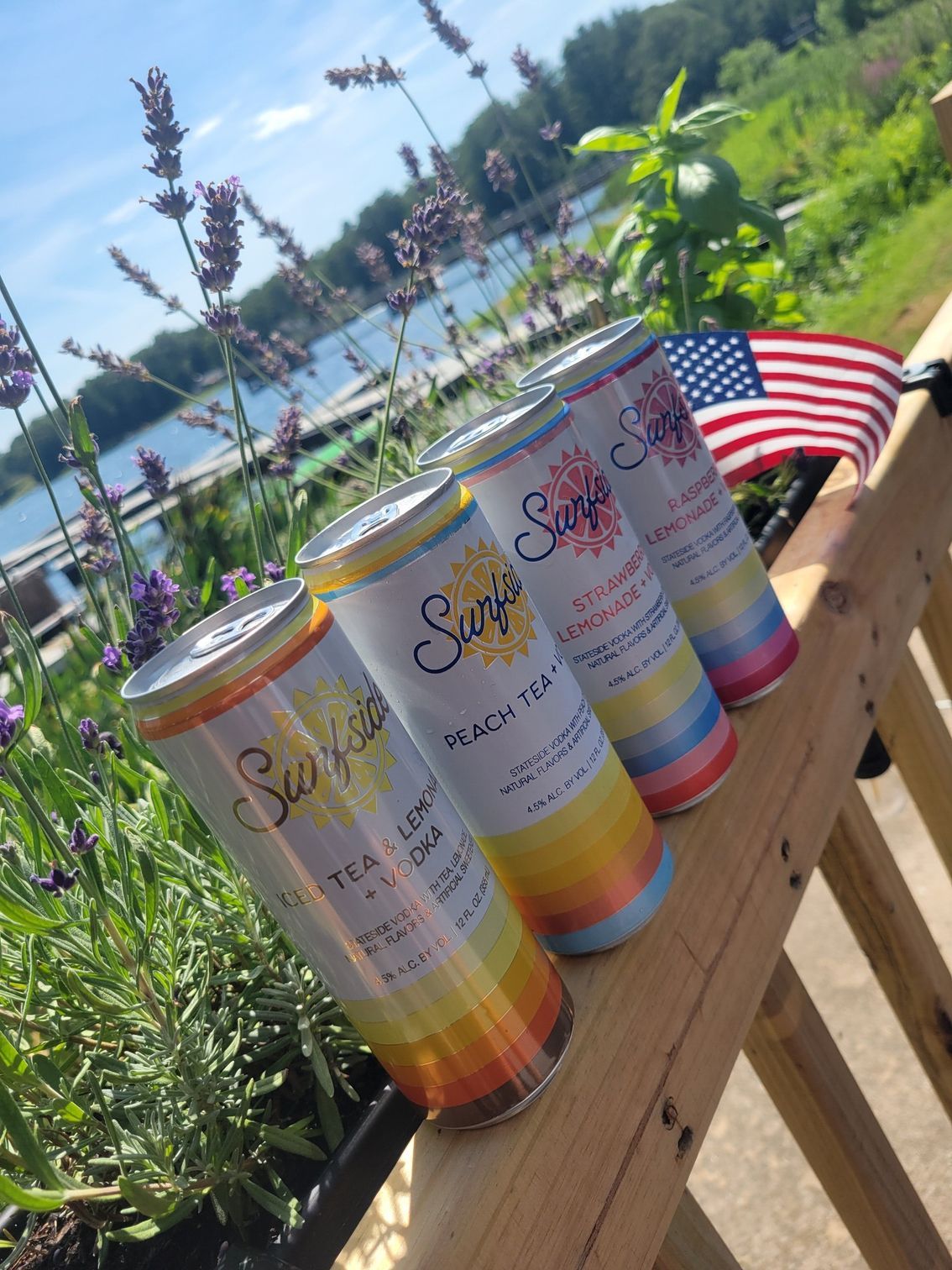 Four cans of soda are sitting on a wooden table.