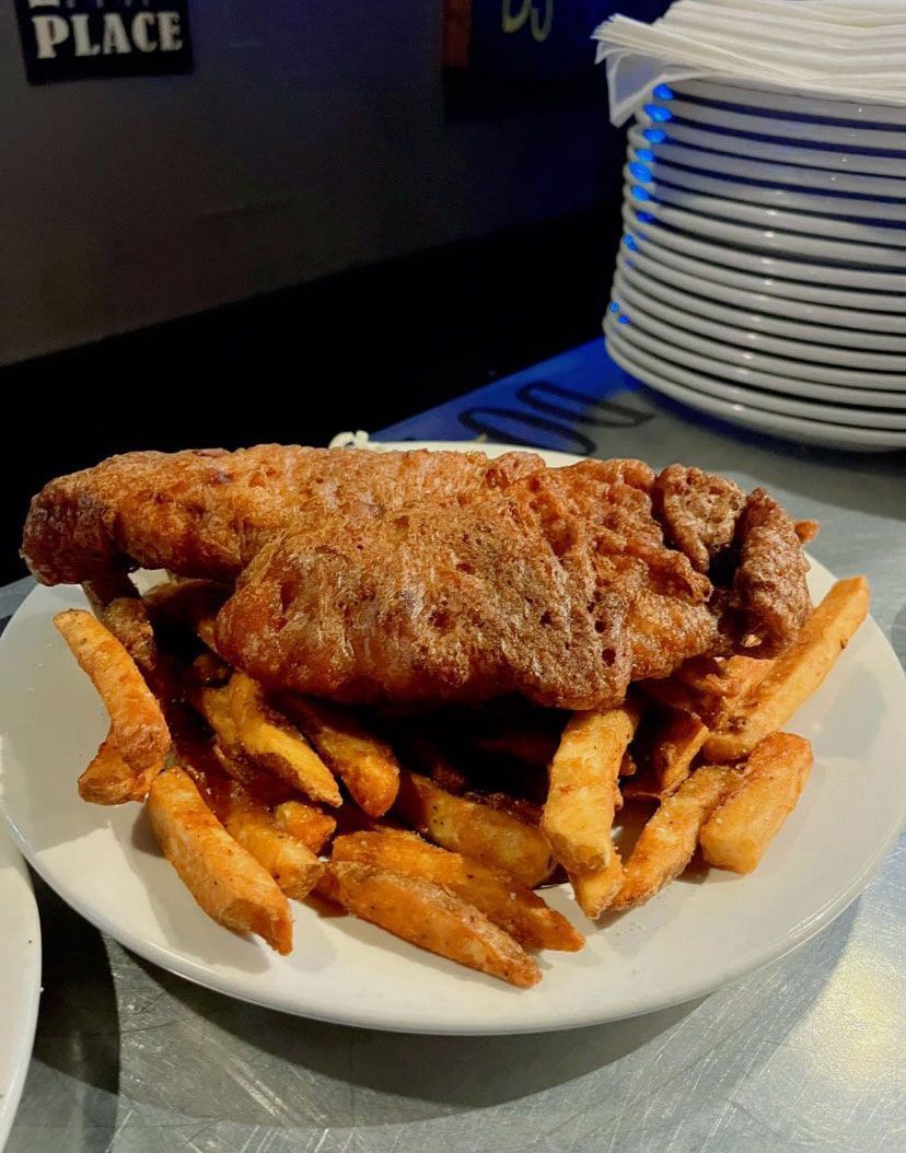 A plate of fried fish and french fries on a table