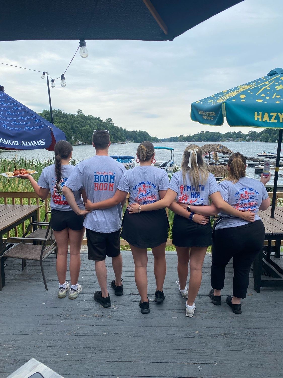 A group of people standing on a deck with their arms around each other.