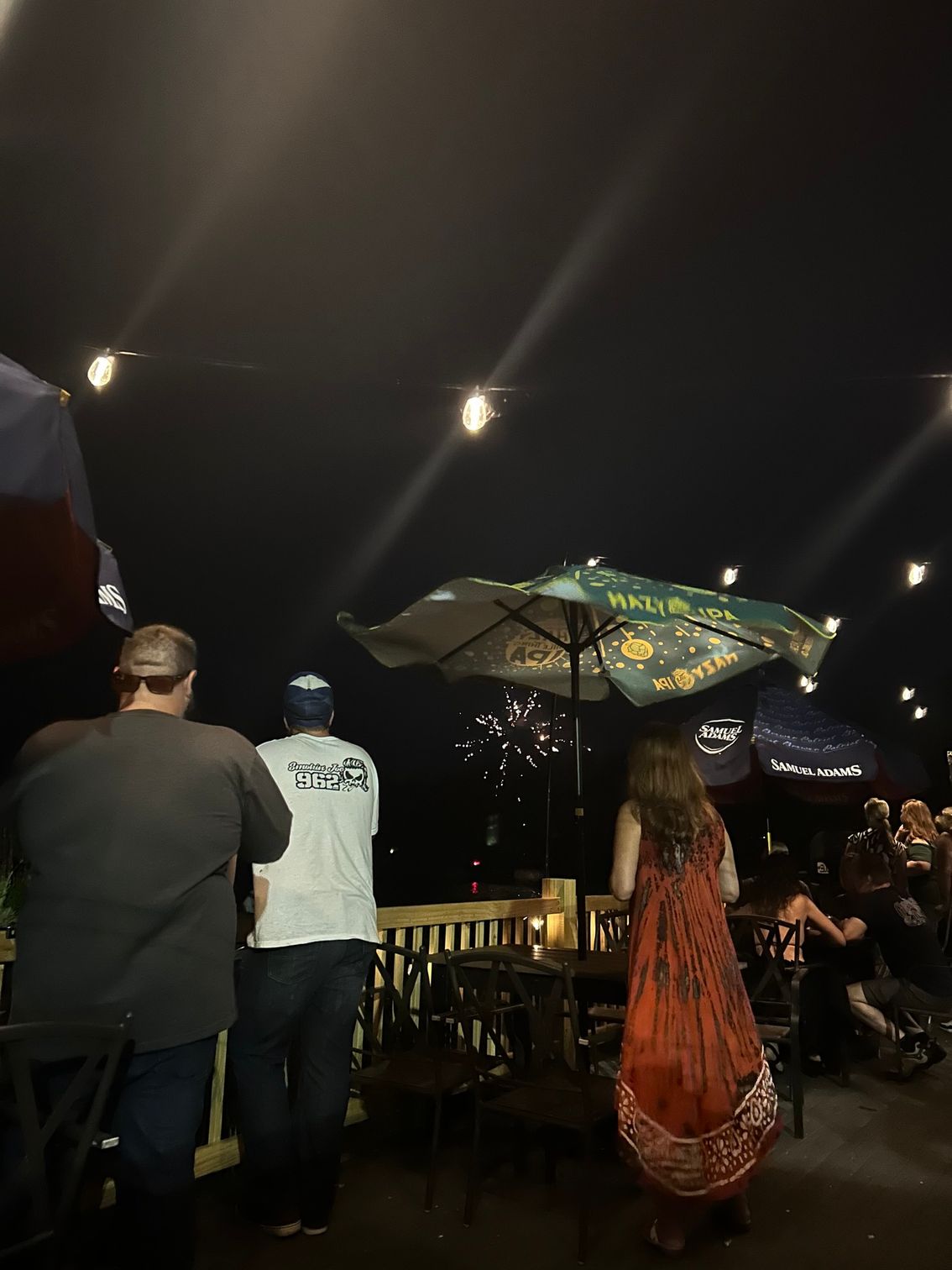A group of people standing under an umbrella in a dark room