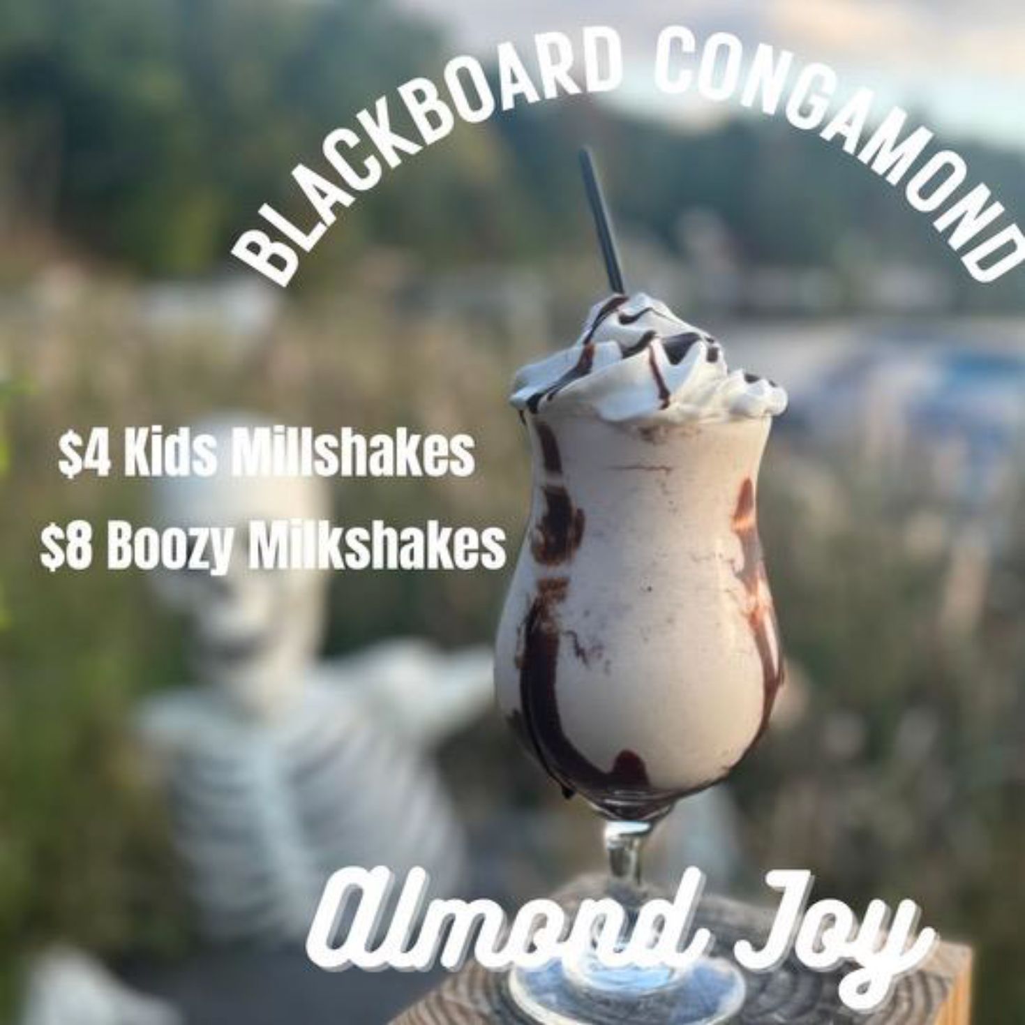 A glass of milkshake with a straw in it that says almond joy.