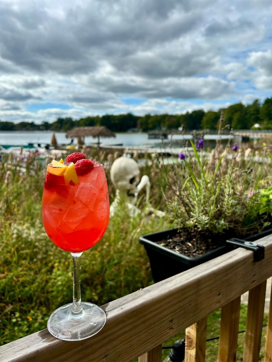 A cocktail is placed on the wooden railing.