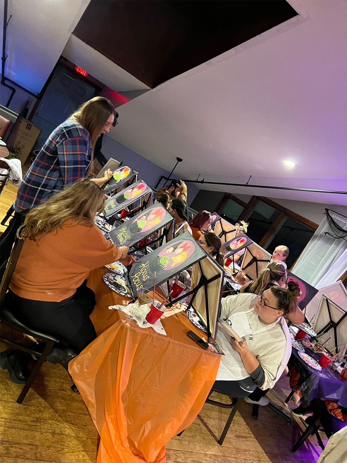 A group of people creating Halloween paintings.