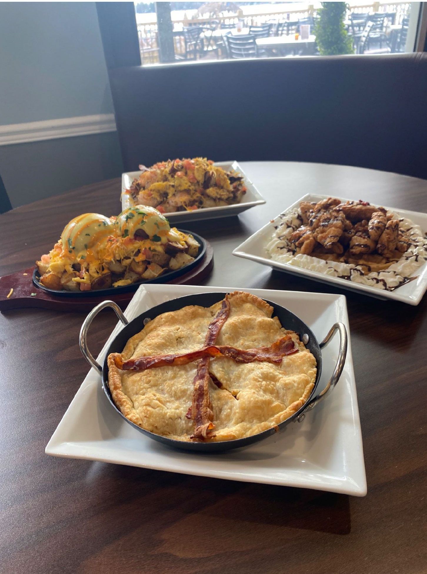 Three plates of food are sitting on a wooden table.