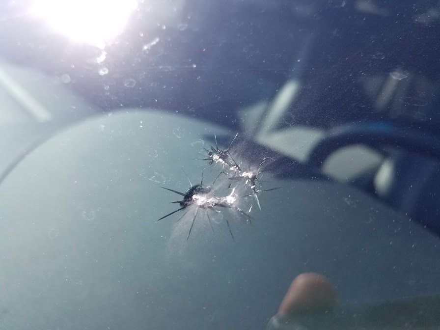 A close up of a cracked windshield on a car.