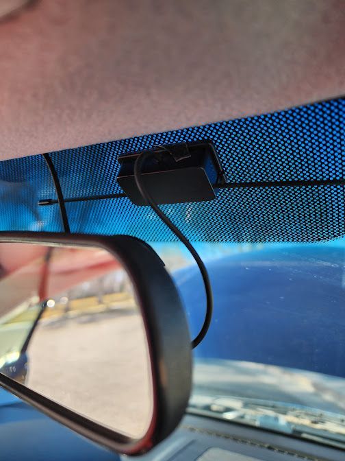 A rear view mirror is attached to the windshield of a car