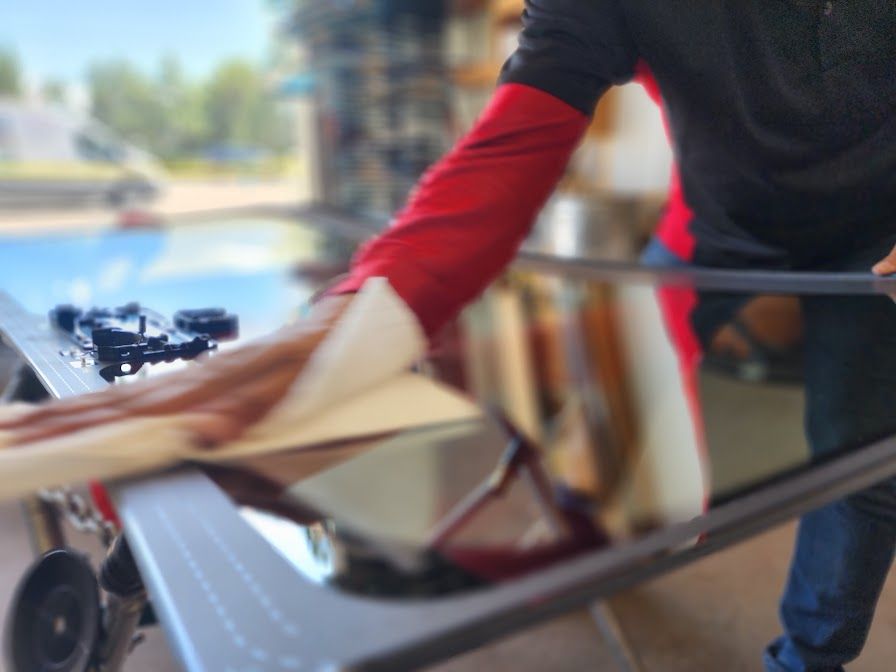 A man in a red shirt is holding a piece of glass