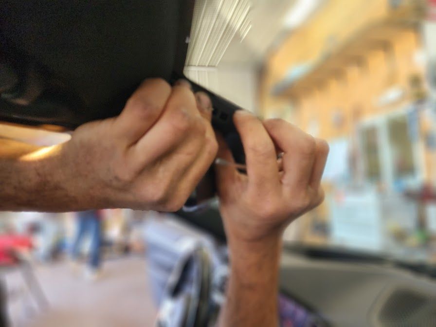 A person is adjusting a rear view mirror in a car