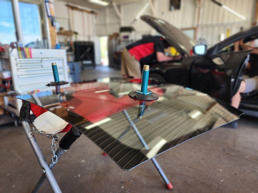 A car windshield is being repaired in a garage.