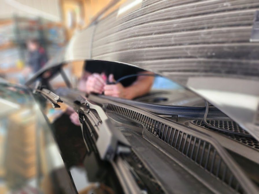 A person is cleaning the windshield of a car.
