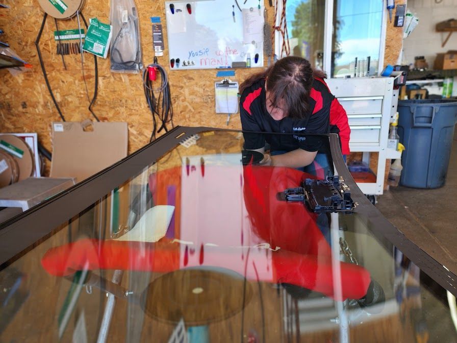 A woman is working on a glass table in a garage