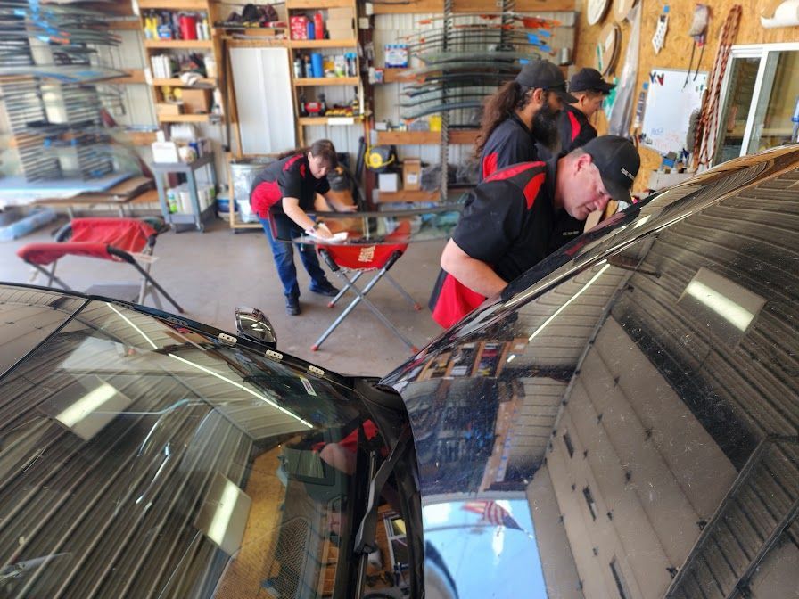 A group of people are working on a car in a garage.