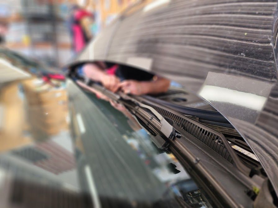 A person is cleaning the windshield of a car.