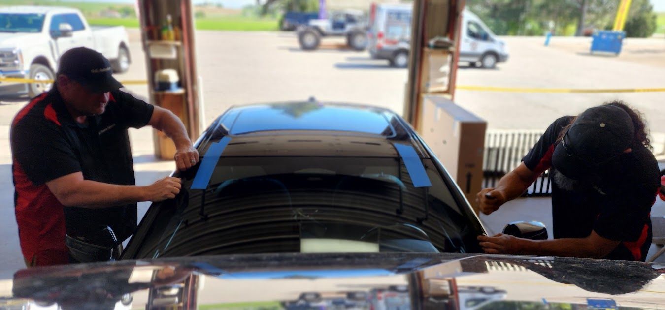 Two men are working on a car in a garage.