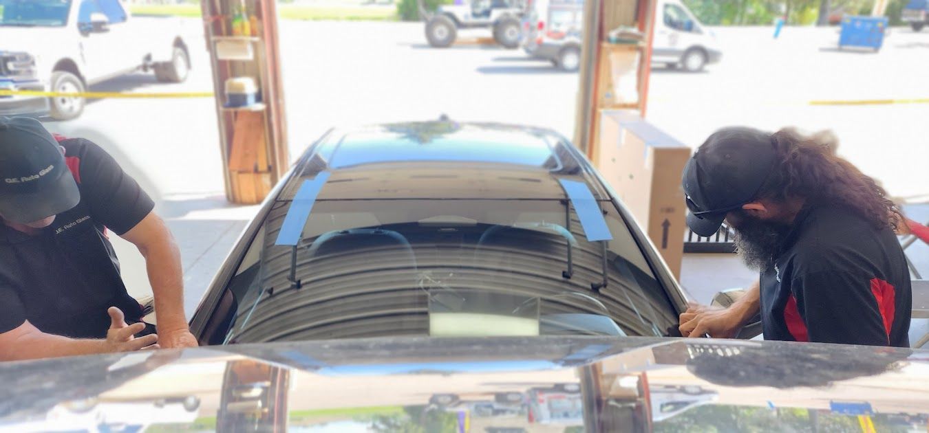 A man and a woman are working on a car in a garage.