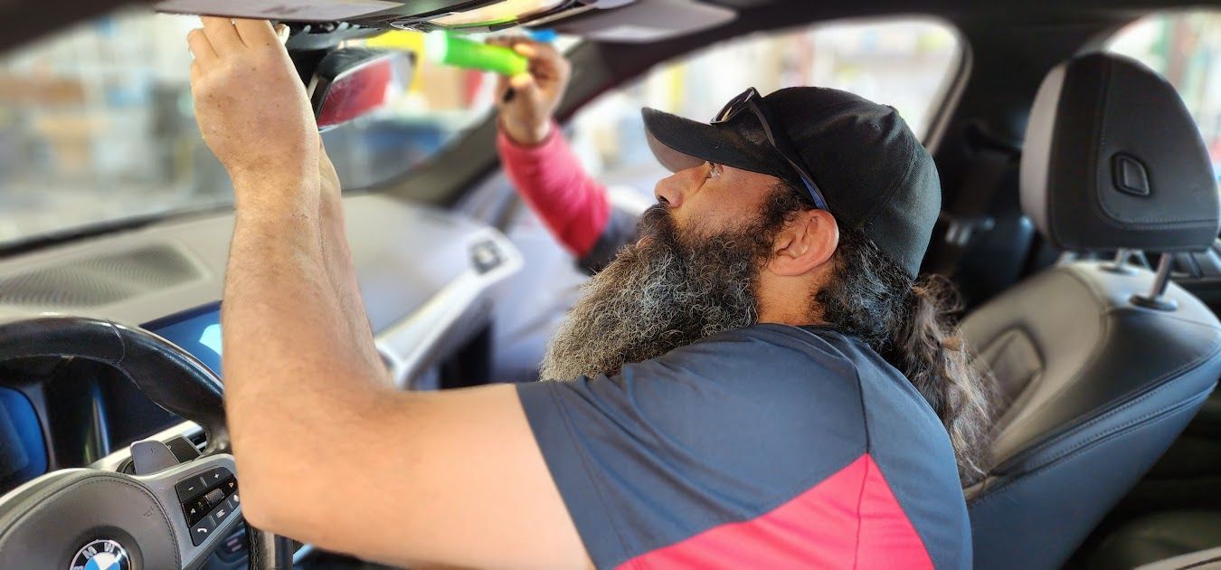 A man with a beard is sitting in the driver 's seat of a car.