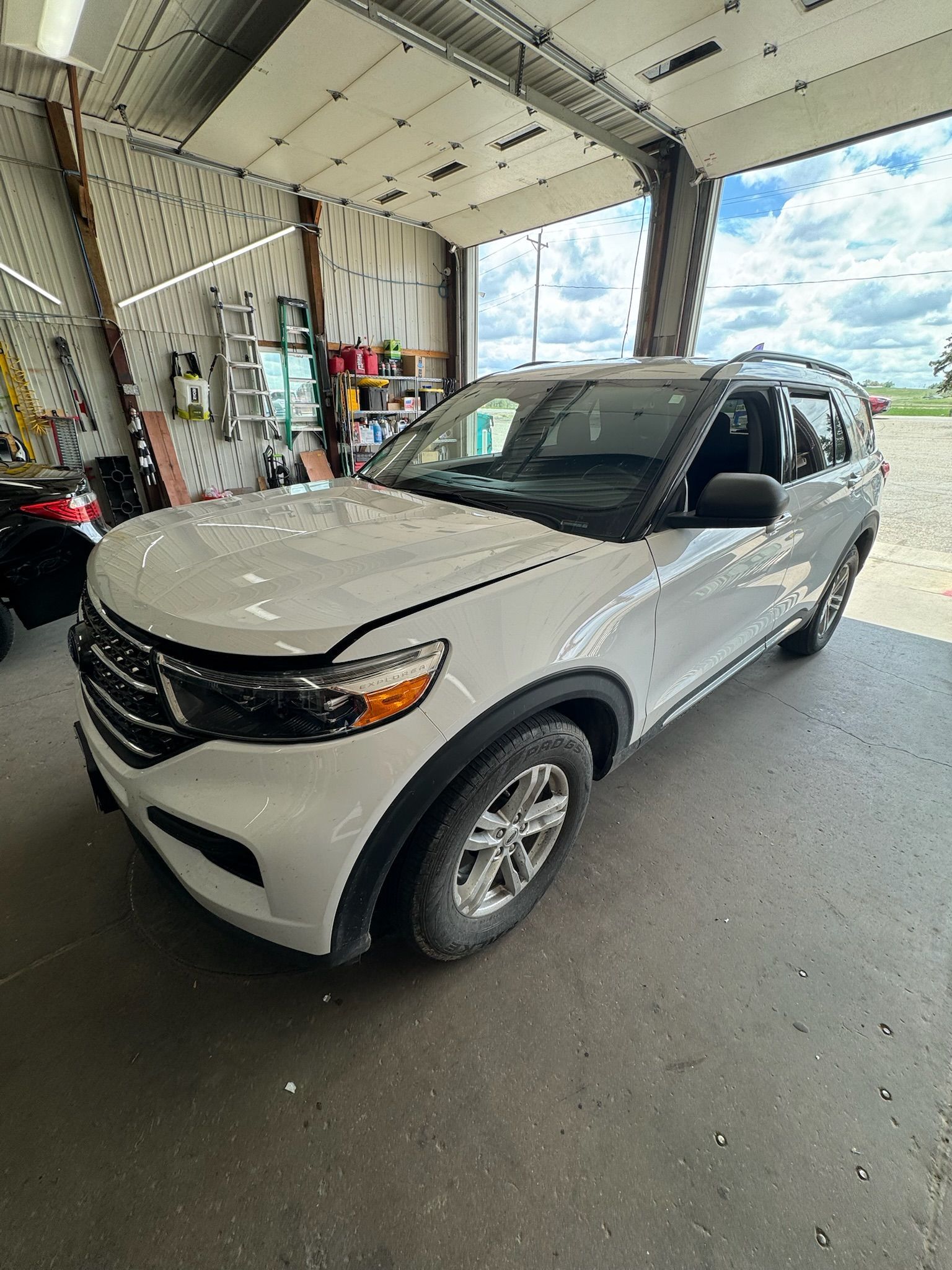 A white ford explorer is parked in a garage.