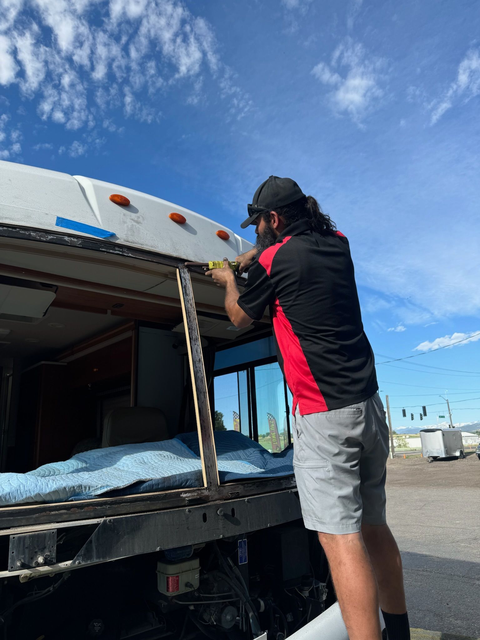 A man is working on the roof of a bus.