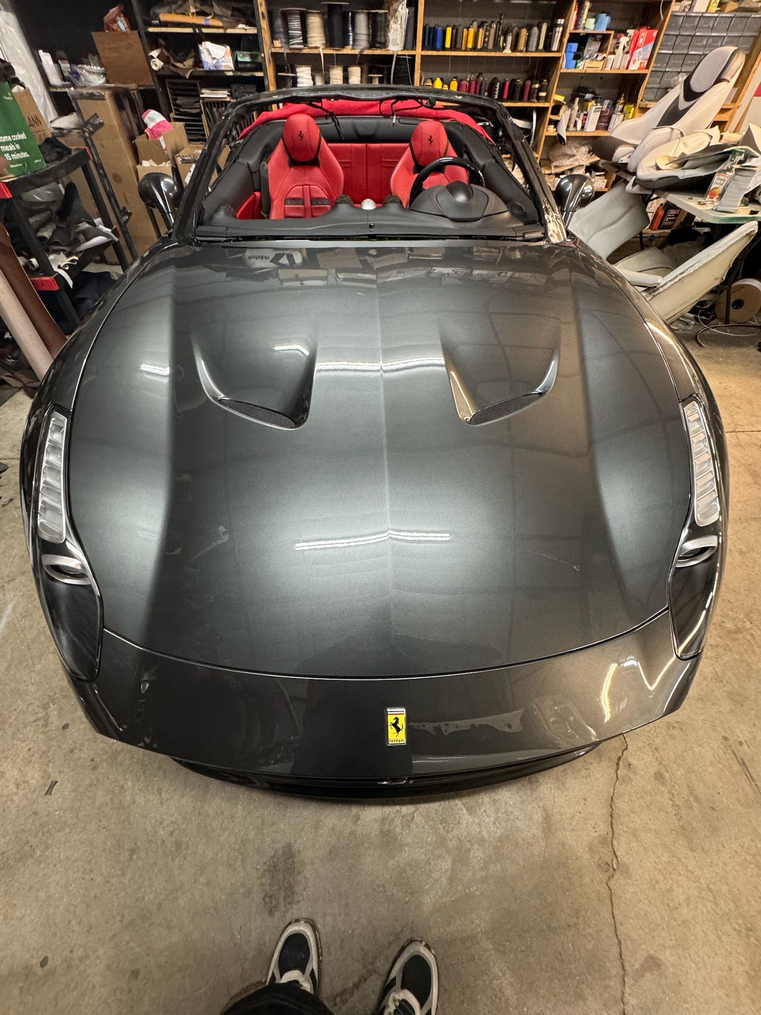 A black ferrari sports car is parked in a garage.