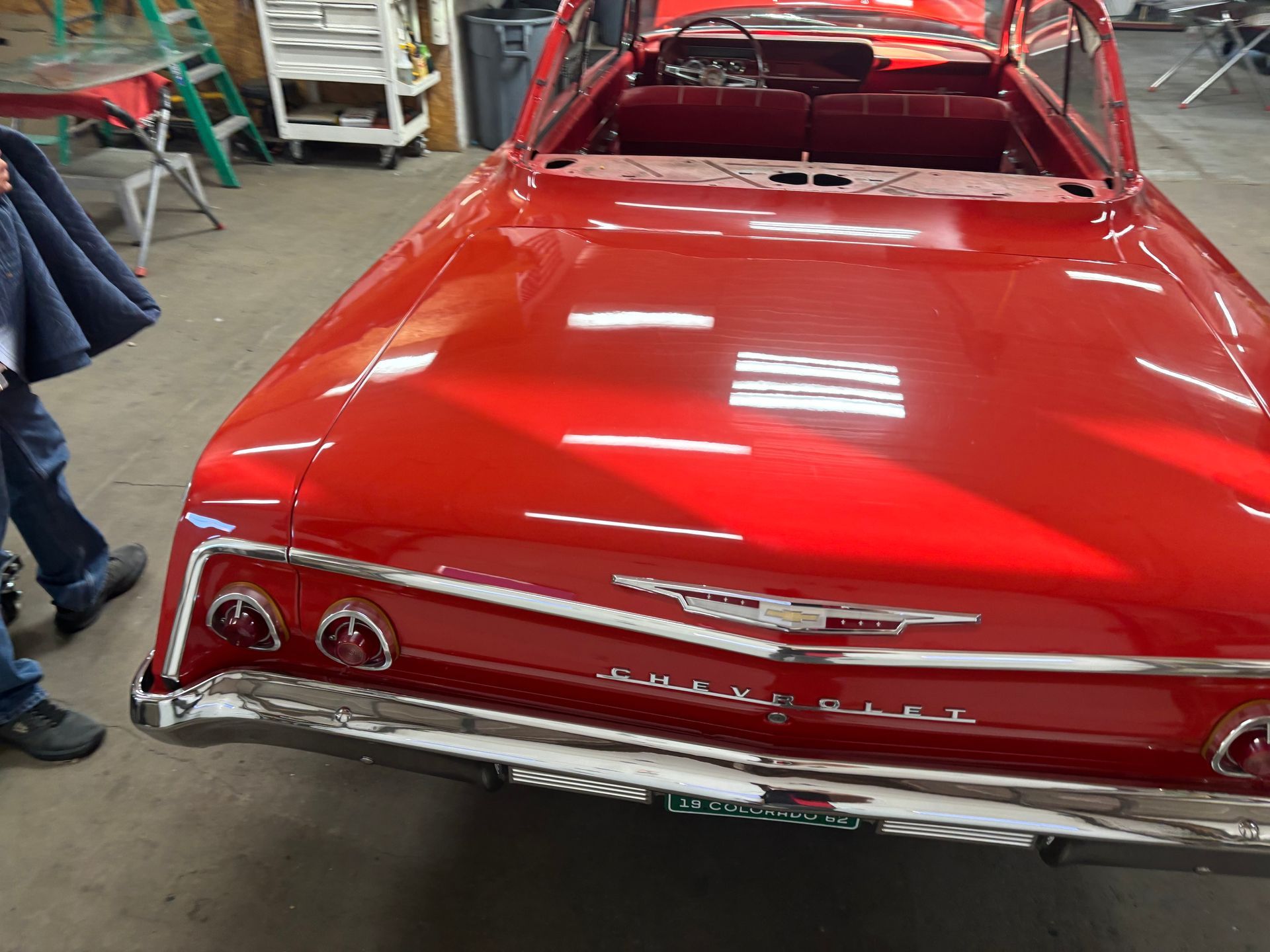 A red chevrolet impala is parked in a garage