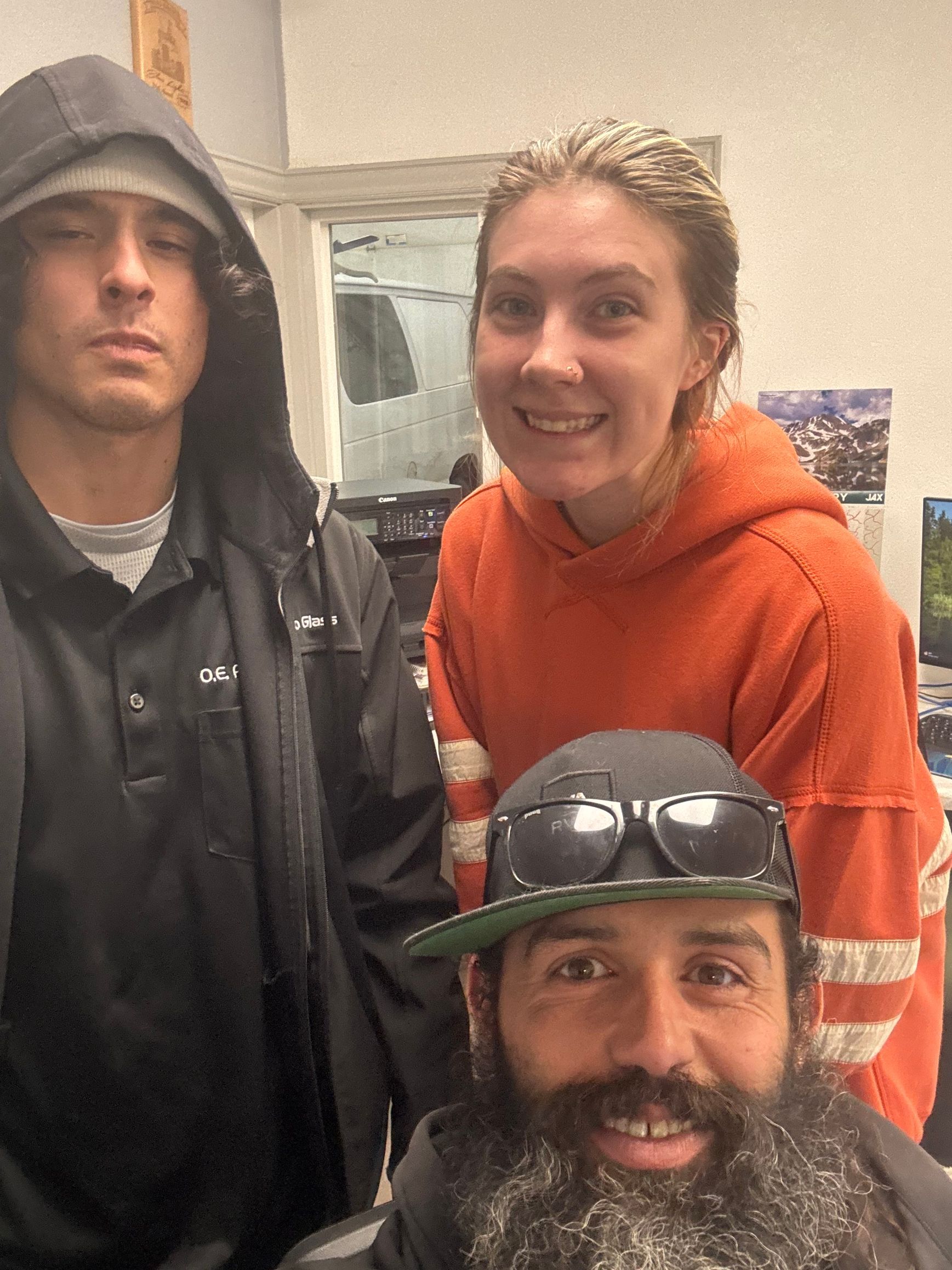 A man with a beard is posing for a picture with two other people.