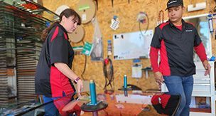 A man and a woman are standing next to each other in a workshop.