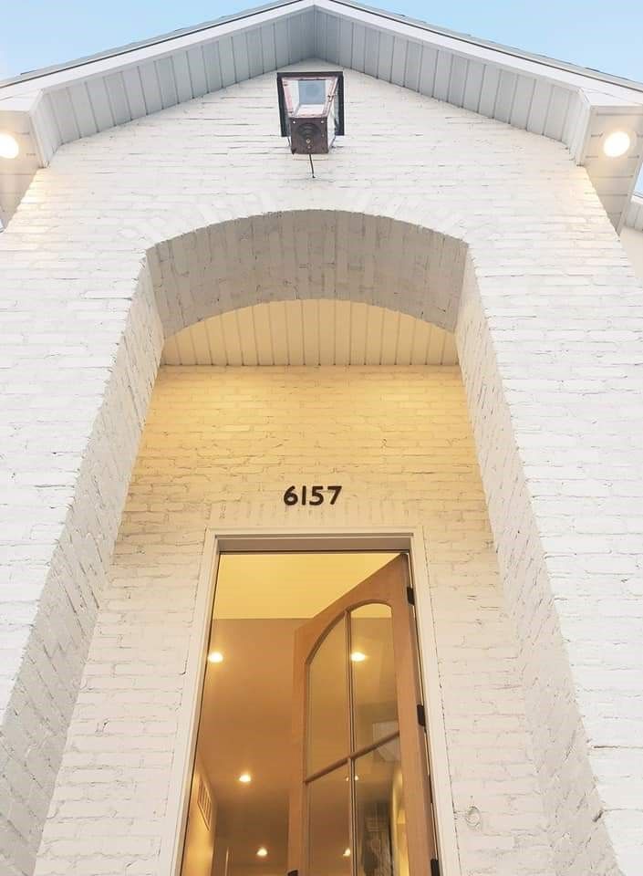 A white brick building with the number 6157 on it