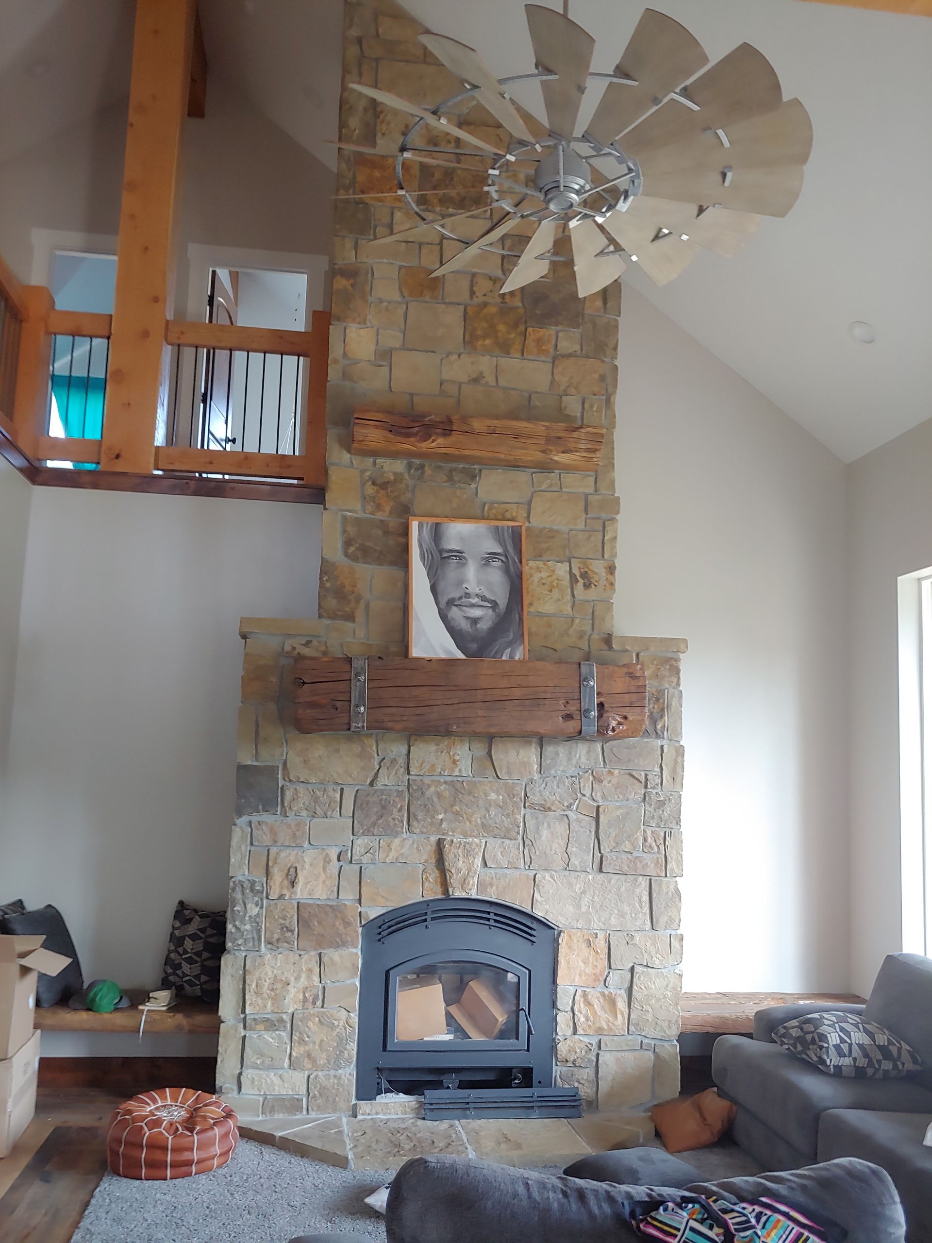 A living room with a fireplace and a ceiling fan