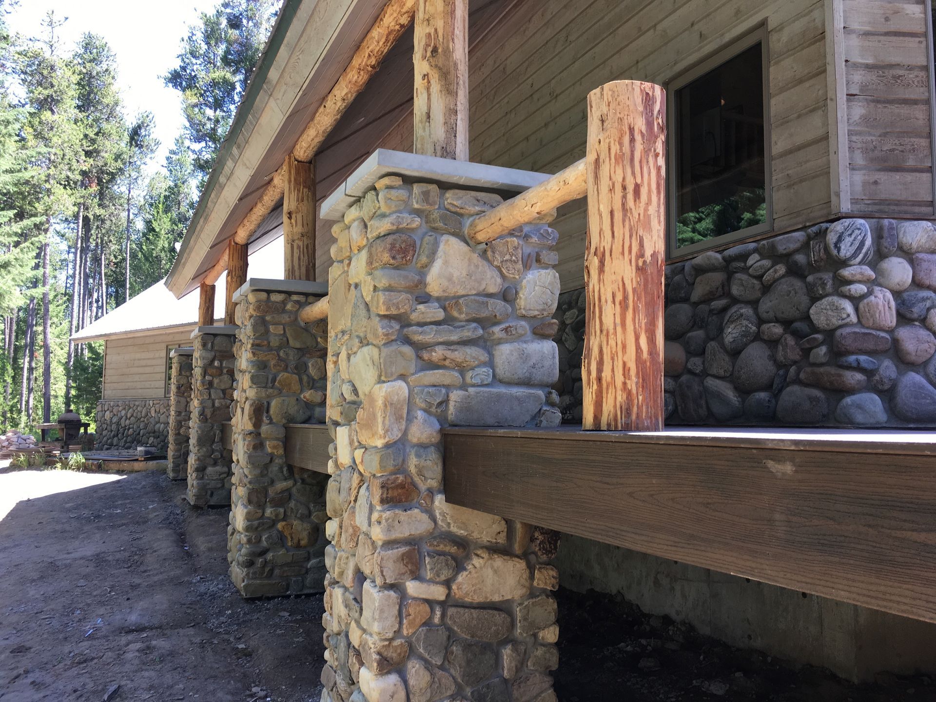 A house with stone pillars and a wooden railing