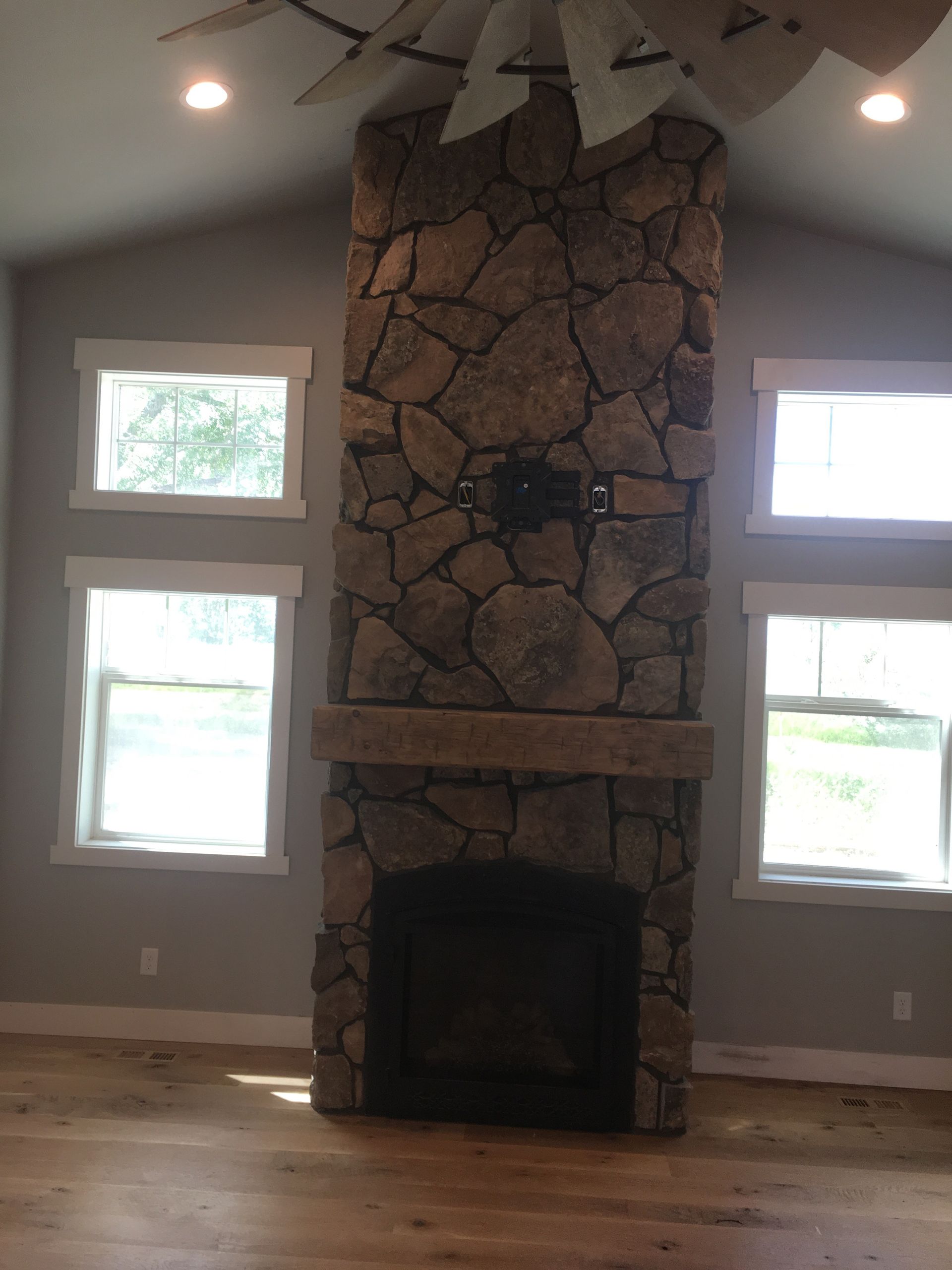 There is a large stone fireplace in the middle of the room