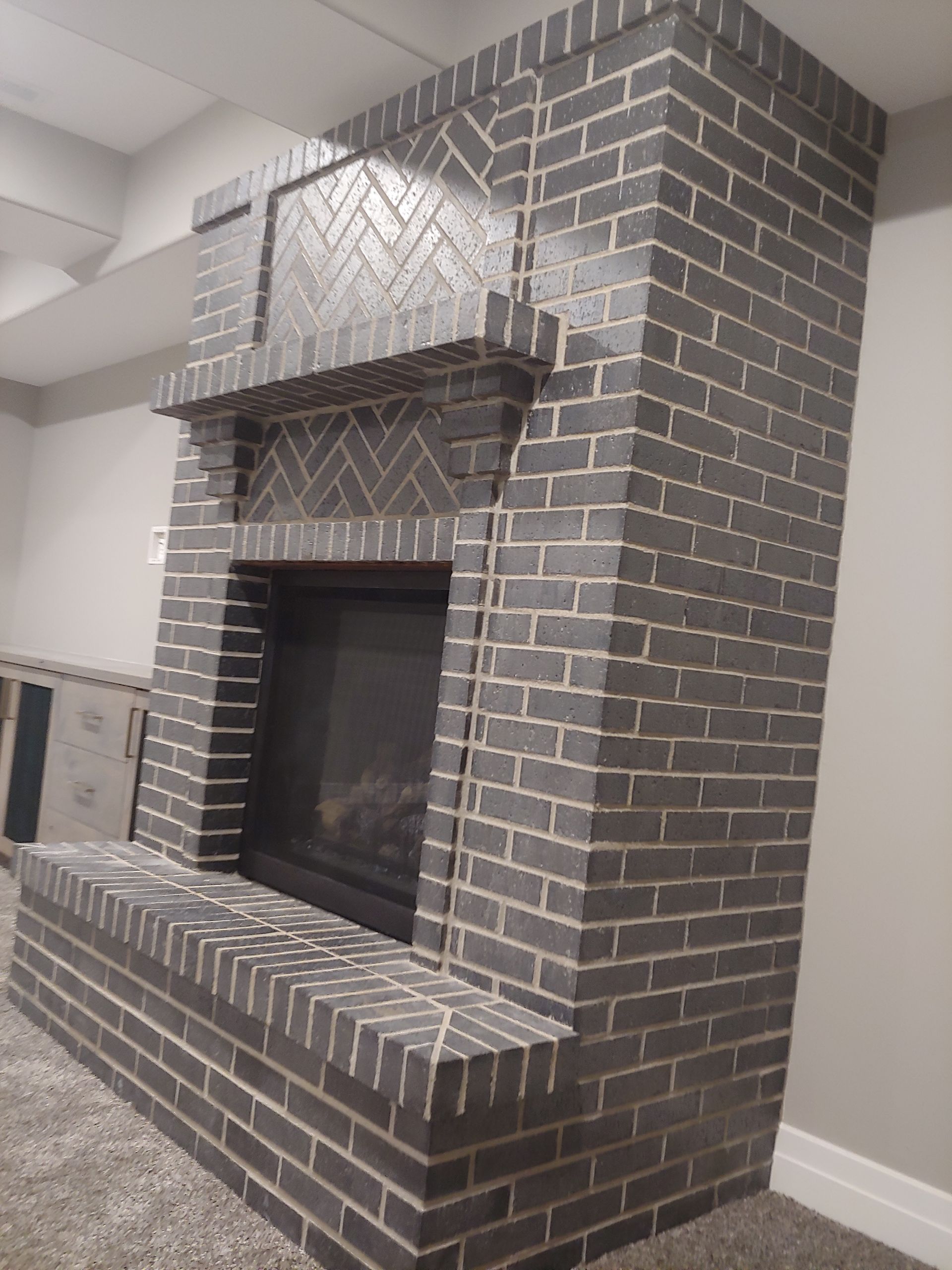 A large brick fireplace is sitting in a living room