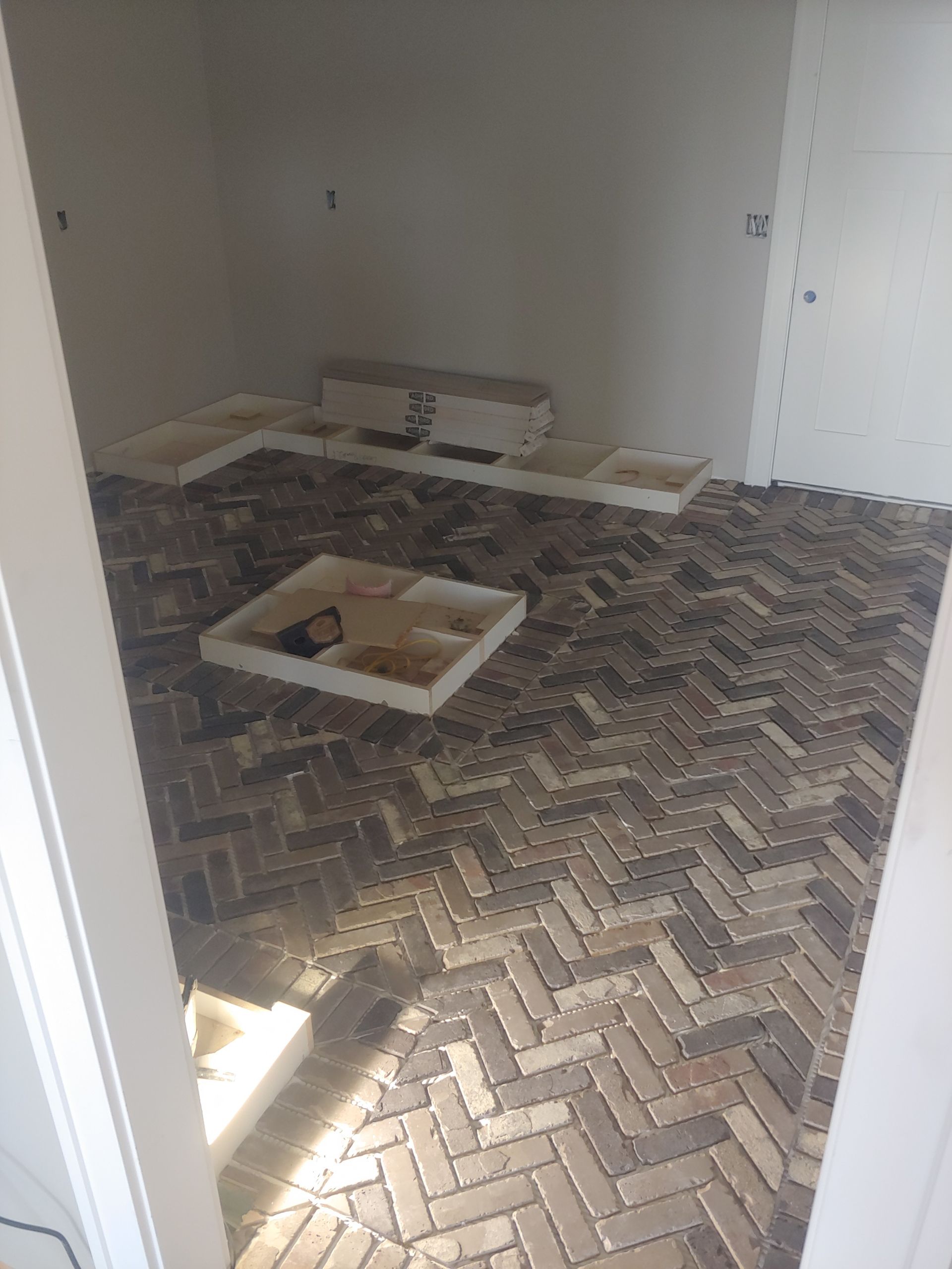 A room with a brick floor and a box on the floor