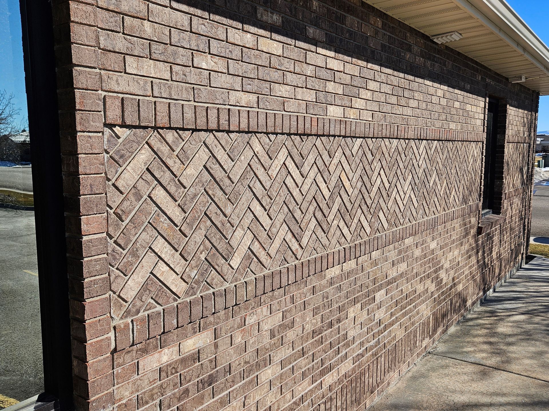 A brick wall with a herringbone pattern on it