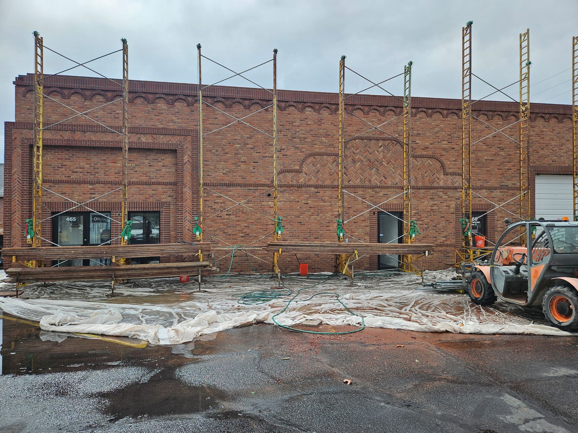 A tractor is parked in front of a brick building