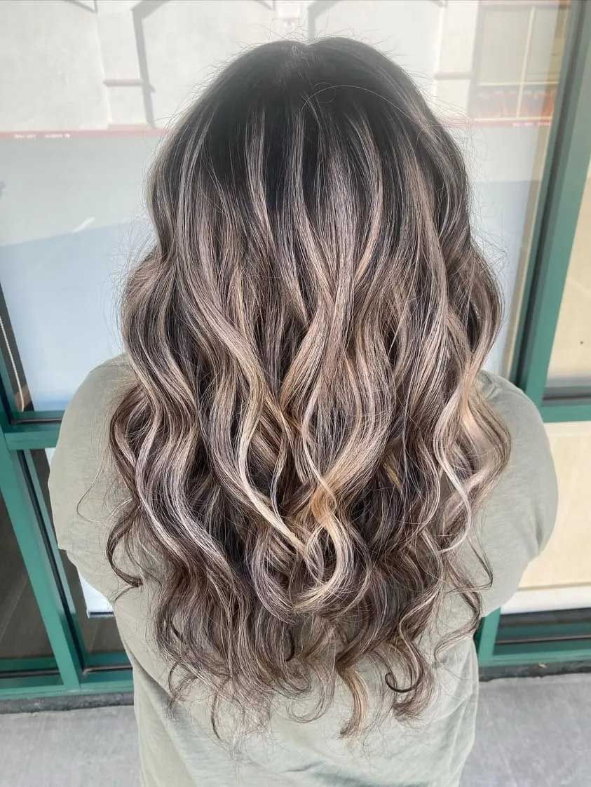 Woman with long, wavy hair. The hair is dark at the roots and fades to light blonde at the ends.