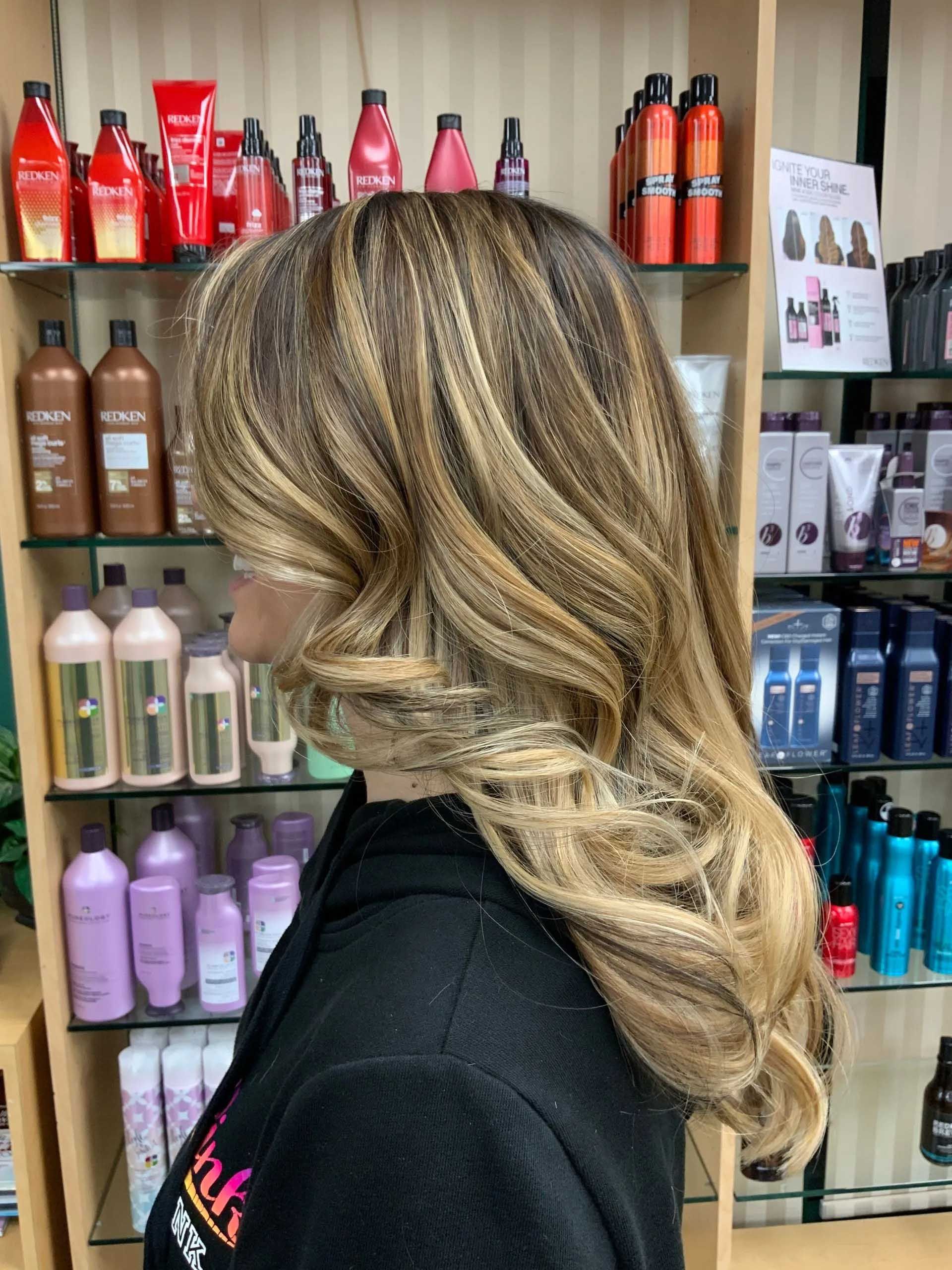 Woman with wavy, highlighted hair in a hair product store.