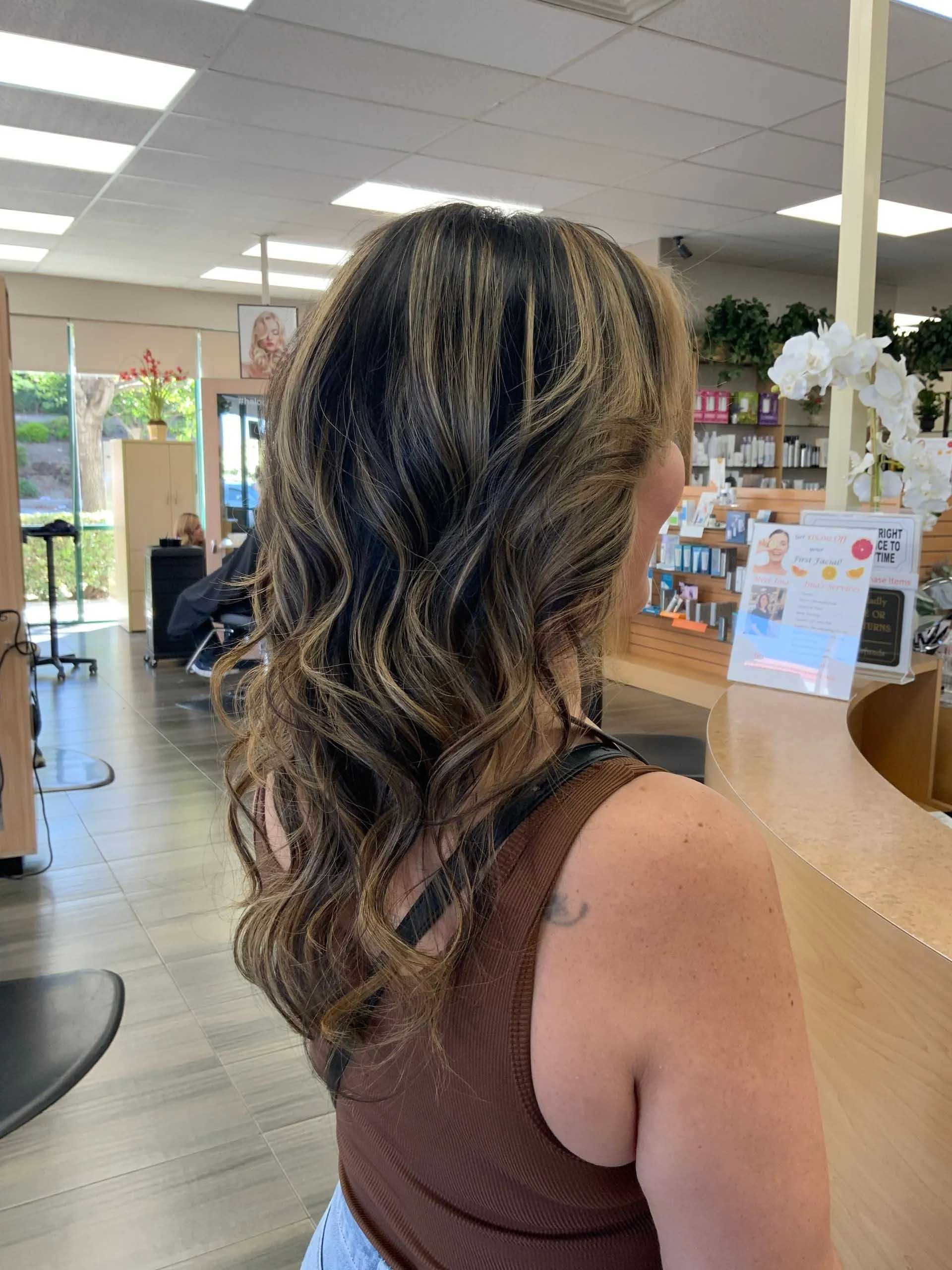 Woman with wavy highlighted hair in a hair salon.