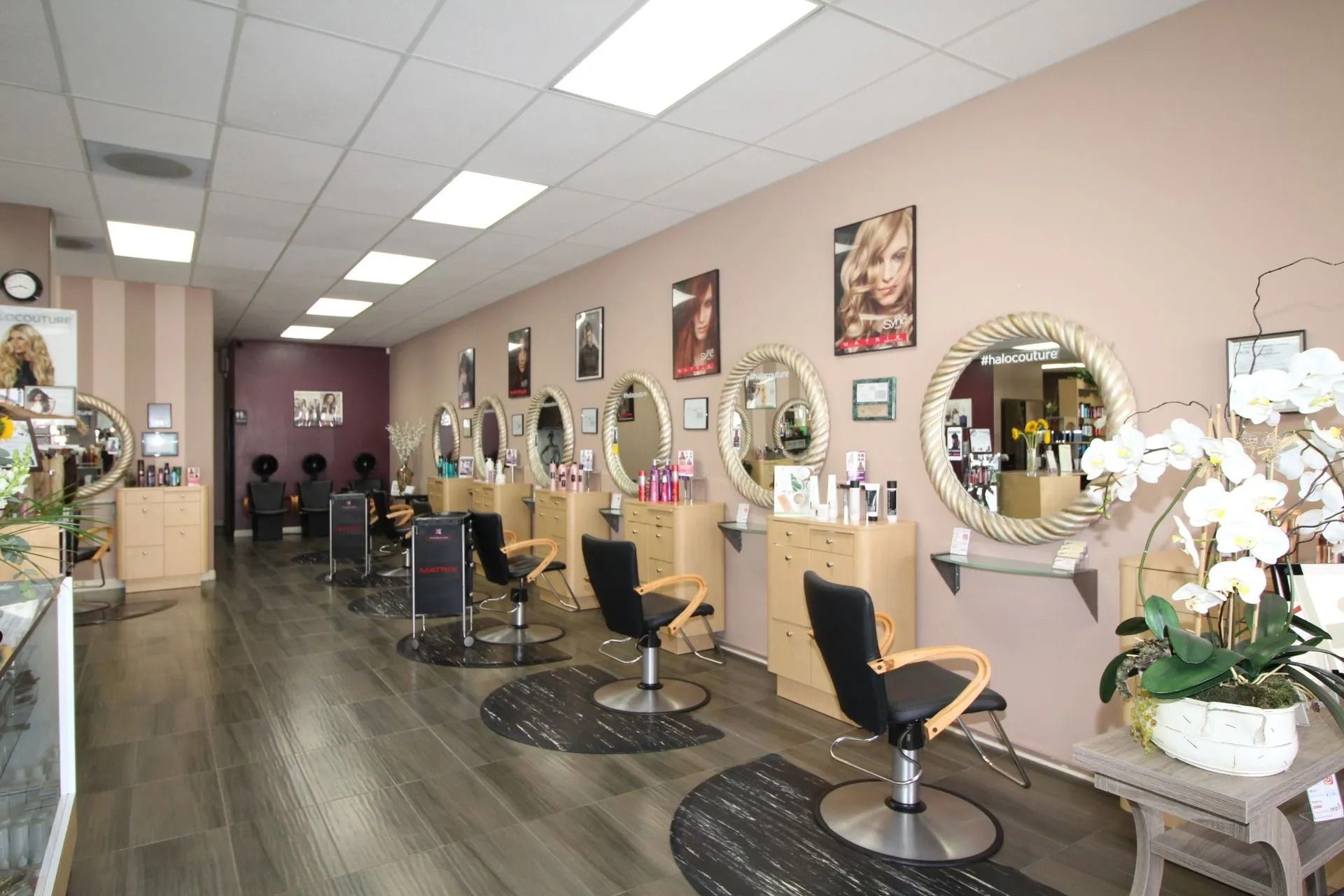Hair salon interior with styling stations, mirrors, and products.