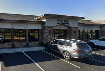 A car is parked in front of a building that says chapel ridge law building.