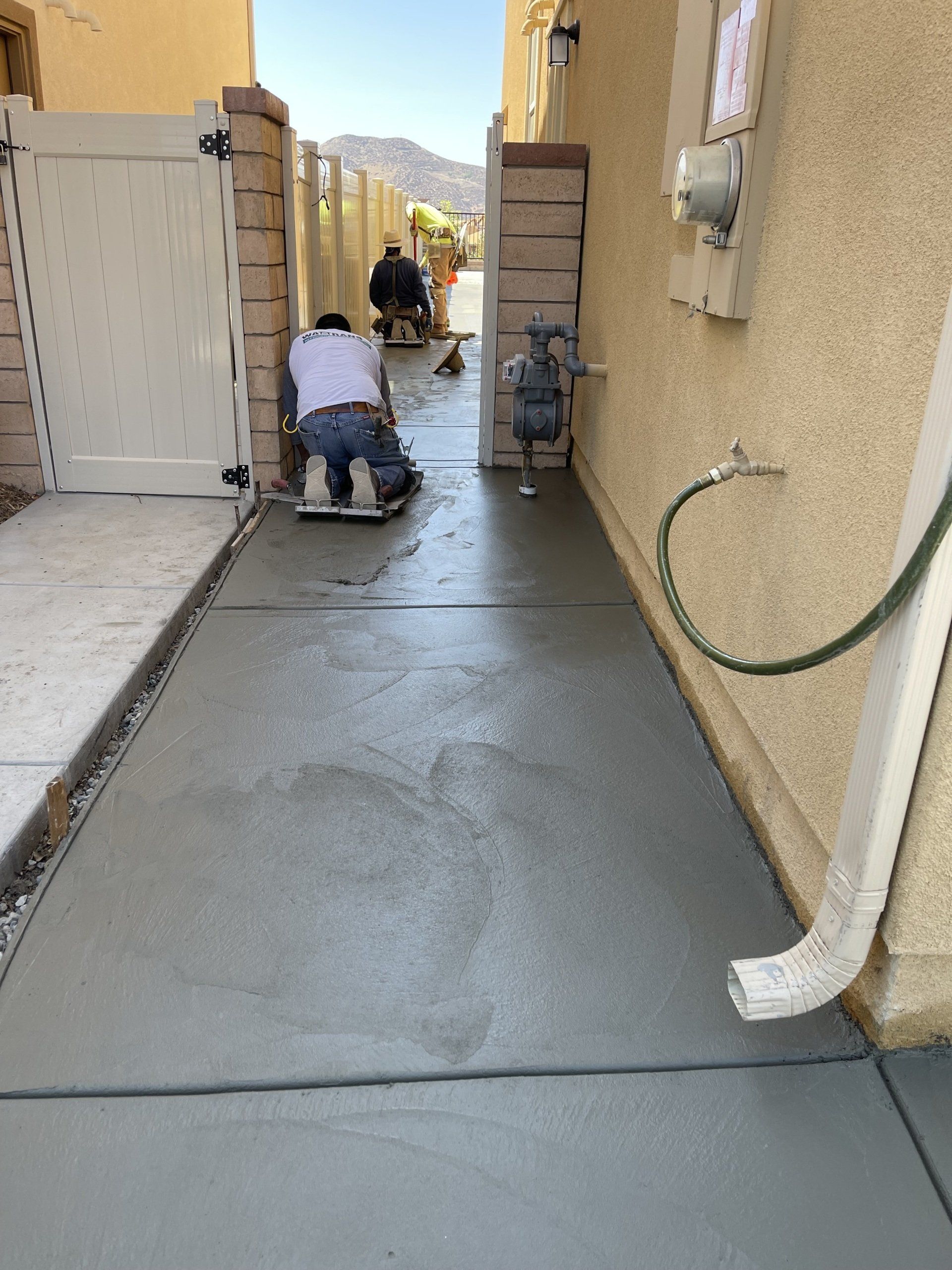 men working on house sidewalk